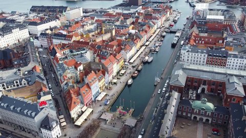 Copenhagen, Denmark - February 22 2022: Aerial drone footage of the Nyhavn harbor that is famous for its colorful houses in the heart of Copenhagen historic city center. 