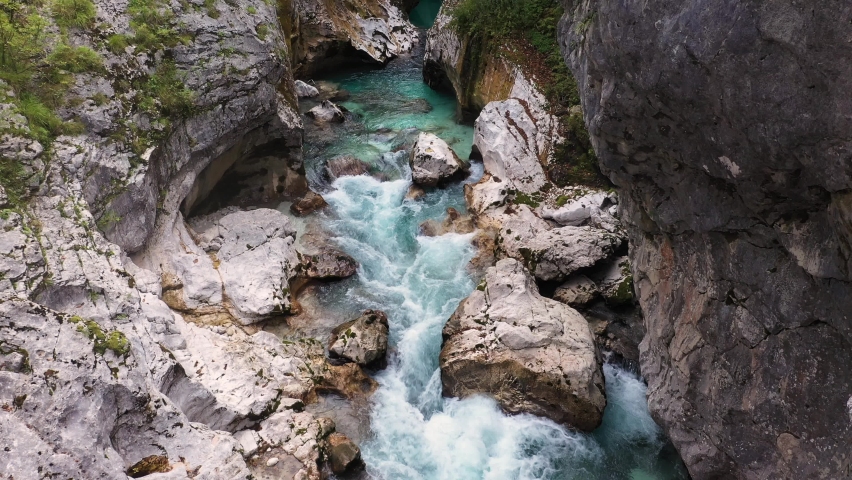 Aerial View Above The Surface Of A Mountain River Soca , stream flowing through rocky canyon. River stones with flowing water, clean water flowing in a mountain river | Shutterstock HD Video #1087695296