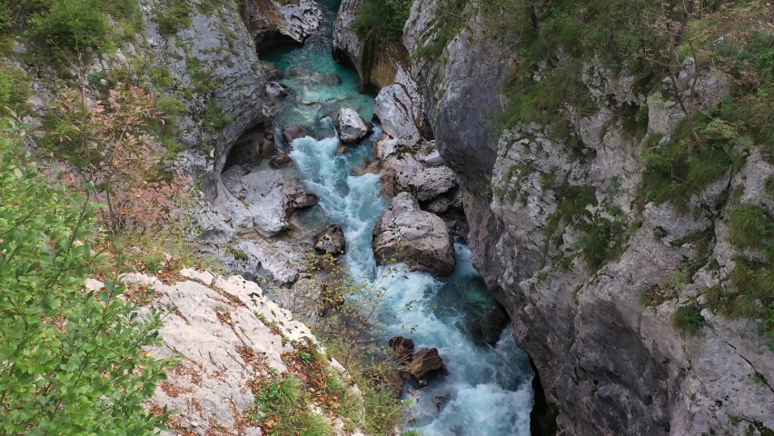 Aerial View Above The Surface Of A Mountain River Soca , stream flowing through rocky canyon. River stones with flowing water, clean water flowing in a mountain river | Shutterstock HD Video #1087695302