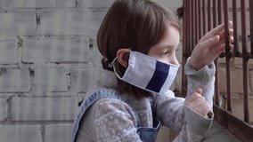 Little girl, child, standing on the balcony, showing her crossed arms in a gesture: I say no. On the child a protective medical mask with a French flag. Concept of viruses and diseases, Stay home. - Powered by Shutterstock - Get 15% off with code: PIKWIZARD15