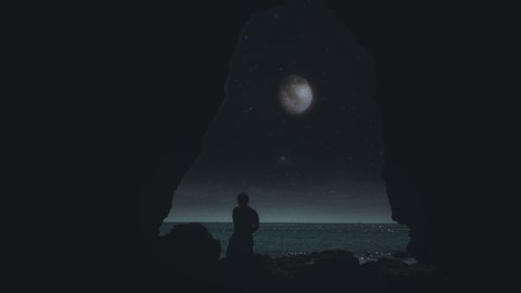Full Moon Ocean Cave Crack Silhouette Man Walking. Man walking over rocks inside an ocean cave with view to the full moon