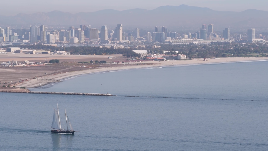 San Diego city skyline, cityscape of downtown with highrise skyscrapers, California coast, USA. View of Coronado island from above, Point Loma vista viewpoint. Frigate sail-powered ship, windjammer.