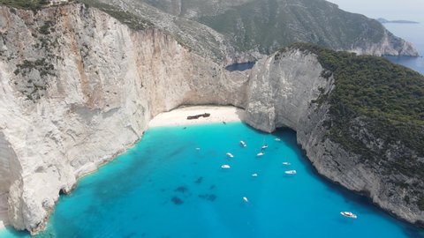 Stunning aerial view of Navagio beach with white sand, clear crystal water and sunny blue sky,