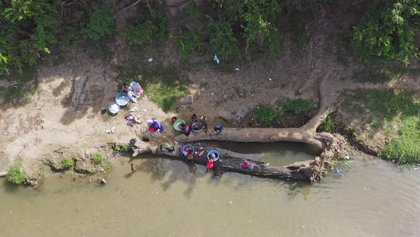 Haitian women washing clothes in waters of Massacre River. Border between Haiti and Dominican Republic. Aerial top-down directly above