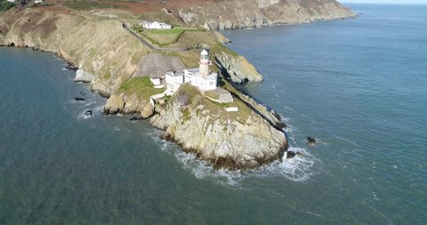 Flying over the pier, the beautiful elements of the coast are on show such as the lighthouse, the colour varying grass and the colour transition of the littoral land in Ireland