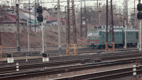 Locomotive with a passenger electric train at the railway station. Old locomotive moving by rail.