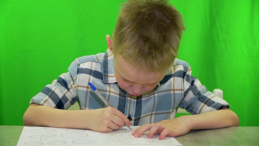 Boy 5 years old writes in a notebook