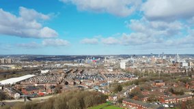 Aerial footage of the town centre of Leeds in West Yorkshire, flying on the borders of Leeds in the village of Bestow on a sunny day in the spring time showing white clouds in the sky