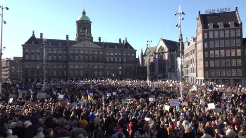 AMSTERDAM, NETHERLANDS – FEBRUARY 27 2022: Crowds of people rally against the war in the Ukraine, in front of the Royal Palace in Amsterdam. Worldwide condemnation of Russia's invasion of Ukraine.