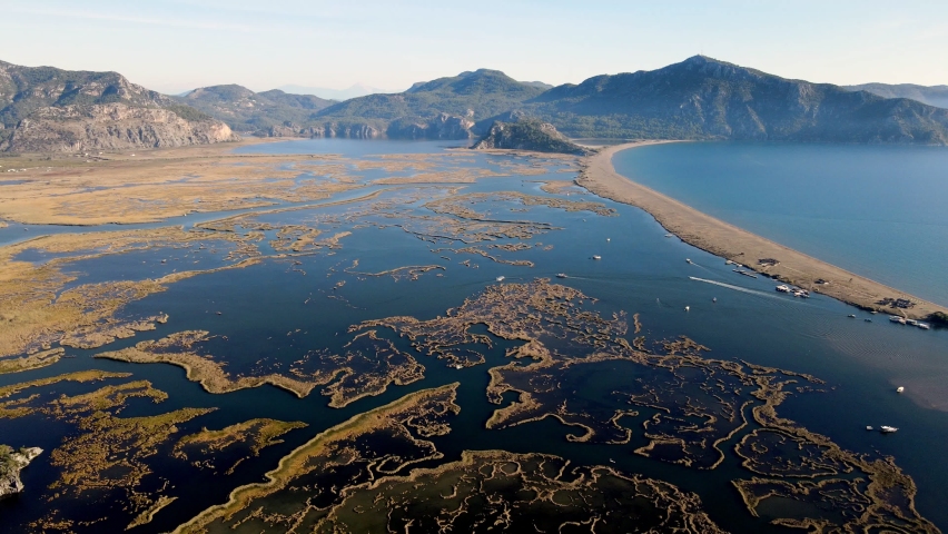 A shining summer sun and people sunbathing on the beach while enjoying the boat at Muğla Iztuzu Beach, one of Turkey