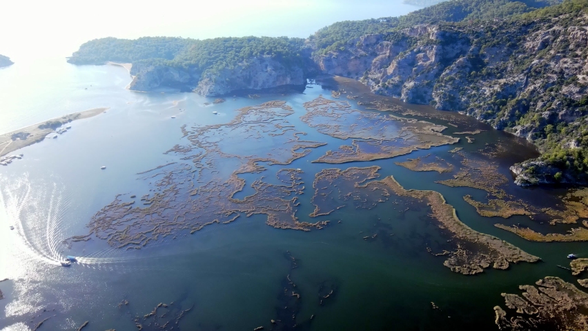 A shining summer sun and people sunbathing on the beach while enjoying the boat at Muğla Iztuzu Beach, one of Turkey