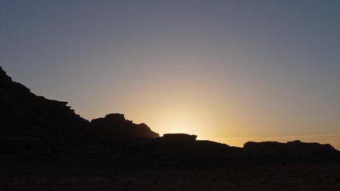 Sunset in Wadi Rum the valley of the moon in the Jordan desert, silhouette of the canyon big rocky mountain formation, famous travel tourist destination