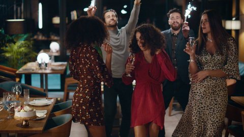 Friends celebrating new year together on fancy party meeting at night restaurant. Multiethnic group dancing having fun time et evening cafe. Young people moving body to music. Leisure gather concept. Arkivvideo