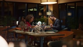 Multiracial couple sharing food dinner in italian restaurant on date. Beautiful couple eating delicious meal in modern style cafe. Two people celebrate valentines day together. Romantic time concept. - Powered by Shutterstock - Get 15% off with code: PIKWIZARD15