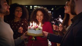 Birthday girl blowing cake burning candles on night restaurant party. Multiracial friends sing on festive celebration. Close up happy people group enjoying surprise event. Having fun together concept. - Powered by Shutterstock - Get 15% off with code: PIKWIZARD15
