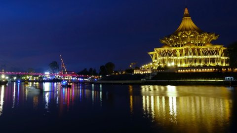  Kuching, Malaysia-Circa February, 2022: A panning timelapse footage from bright to dark with noise effect Sarawak State Asembly building and other landmark insight. 