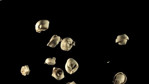 Frozen raw dumplings go up and down. On a black background. Filmed is slow motion 1000 fps. High quality FullHD footage