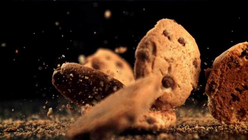 Cookies with pieces of chocolate fall on the table and crumble. On a black background. Filmed is slow motion 1000 fps.High quality FullHD footage Royalty-Free Stock Footage #1087739657