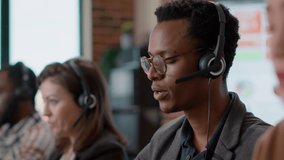 African american worker having conversation on headset with client, offering telemarketing assistance at call center. Man with headphones and microphone working at customer service. Close up. - Powered by Shutterstock - Get 15% off with code: PIKWIZARD15