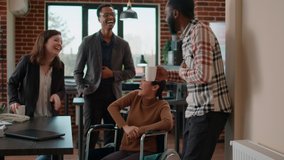 Business people meeting in office to have fun conversation, feeling cheerful and laughing together. Young workers enjoying break and collaborating in disability friendly office. - Powered by Shutterstock - Get 15% off with code: PIKWIZARD15