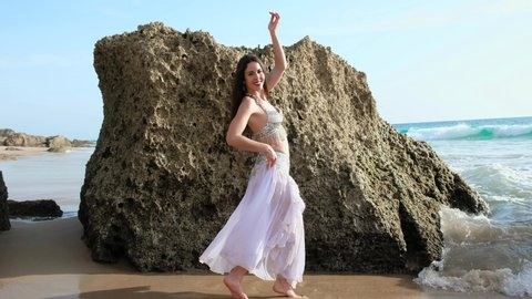 Woman dancing belly dance on the beach