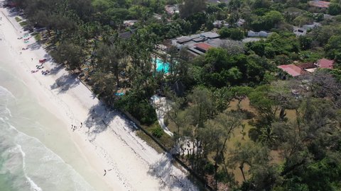 Diani beach Kenyan coast African Sea drone aerial 4k waves blue indan ocean tropical mombasa turquoise white sand East Africa palms paradise hotel view diani sea sesort lodge Kenya landscape 