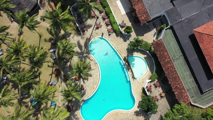Aerial drone top down shot above hotel swimming pool in Diani beach in kenya Africa lodge 