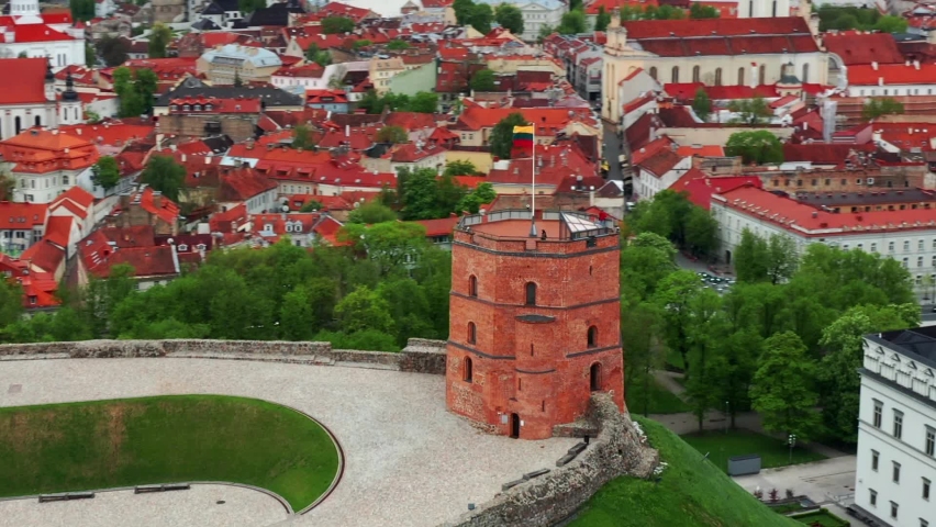 Lithuanian Flag Waving In The Wind At Gediminas Castle Tower In Vilnius Old Town, Lithuania. - aerial orbit Royalty-Free Stock Footage #1087762997