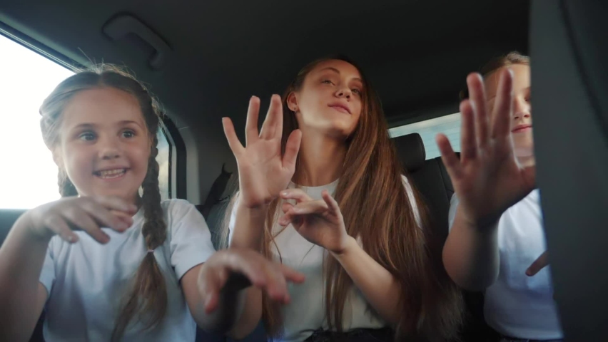 children teenagers dancing in the car on the road travel. happy family adventure a kid dream concept. friendly family sisters dancing fun having to the music in the car on the way to vacation Royalty-Free Stock Footage #1087764734