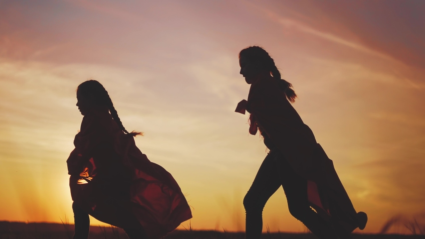 Superhero team. kid dream teamwork a business concept. two girls superheroes with cloaks silhouette running in the park silhouette. sunset child superhero playing. team of children working together | Shutterstock HD Video #1087764887