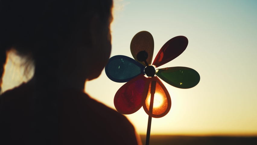 kid pinwheel. little baby girl silhouette play with windmill toy wind in the park. happy family kid dream concept. baby girl play toy pinwheel the glare of the sun at sunset in fun the park Royalty-Free Stock Footage #1087764908