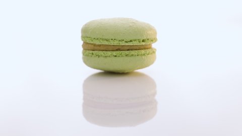 Green macaron pastries rotate on white background. Colorful cake macaroons. Traditional French macaroon. Food concept.