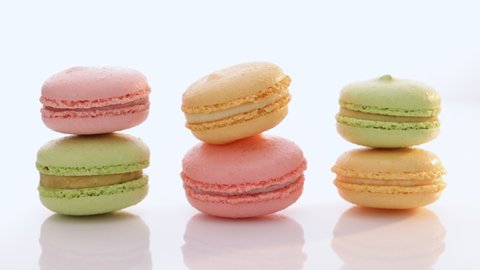 Sweet colorful macarons isolated on white background. Tasty colourful macaroons. High quality video 4k UHD.