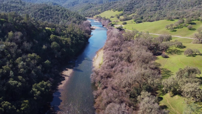 Arial view flying back over Mokelumne River with bridge over water