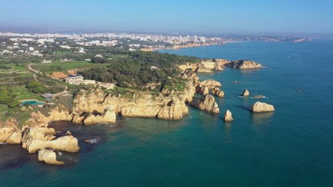 Aerial view of beautiful Portuguese beaches with rocky sandy shores and pure sand for tourists' recreation in the Algarve in the south.