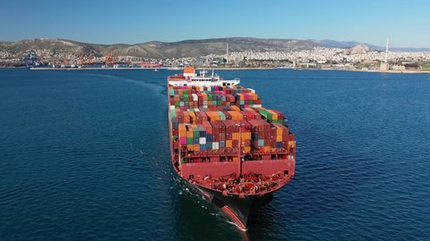 Aerial drone video of bow from huge container carrier tanker ship front bow cruising deep blue sea leaving port of Perama, Attica, Greece
