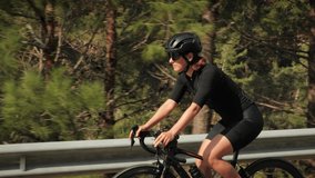 Cyclist riding bicycle in mountains. Cyclist pedaling bike, doing endurance exercising. Athletic concentrated woman in sportswear cycling on bike during competition. Cycling and triathlon concept