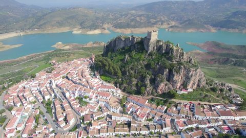aerial view of medieval Andalusian white village near a blue lake, Iberian landmark and Spanish tourist destination, the village of Zahara de la Sierra. High quality 4k footage