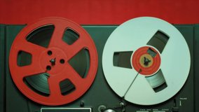 Vintage recording music concept b-roll footage. Close up shot of a reel to reel tape, rolling