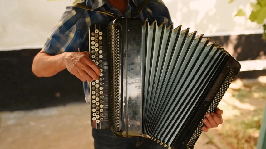 Close-up of hands playing music on accordion with black and white keys and black bellows. Street Musician Hand Playing Accordionist bayan outdoors Close Up. Ukrainian folk music background wedding day | Shutterstock HD Video #1087788458