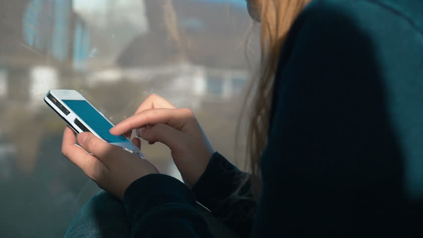 Slow motion shot of a smartphone in female hands. Woman is writing a message on it.