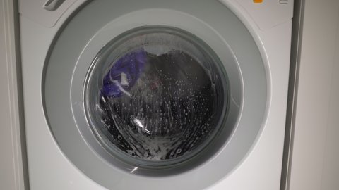 The washing machine washes clothes. The washing machine drum is rotating. Housework of a housewife. Laundry.
