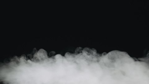 Slow motion of water vapor stream comes from below over black background