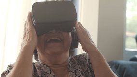 Happy senior woman using VR Headset virtual reality simulator in a living room,Close up