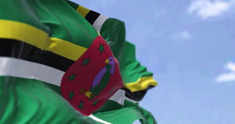 Detail of the national flag of Dominica waving in the wind on a clear day. Dominica is an island country in the Caribbean. Selective focus. Seamless looping in slow motion