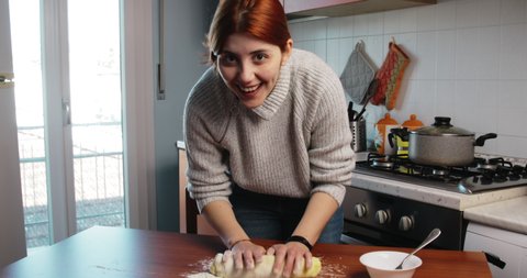 Girl makes the dough on the table for homemade Italian gnocchi