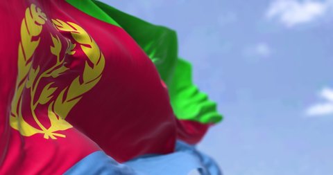 Detail of the national flag of Eritrea waving in the wind on a clear day. Eritrea is a country in the Horn of Africa region of Eastern Africa. Selective focus. Seamless looping in slow motion