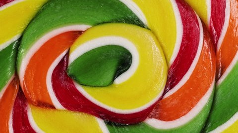 Extreme macro view of a rotation of a spiral fruit lollipop.Caramel lollipops.Sweets for children. childhood concept.