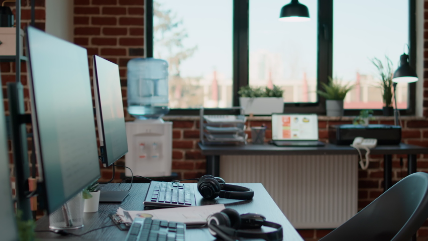 No people at desk with multiple computers in call center office, used by telemarketing agents to answer phone calls on helpline. Empty space with technology to give assistance at customer care. - Powered by Shutterstock - Get 15% off with code: PIKWIZARD15
