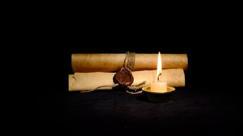 Dark room. A burning candle and medieval scrolls sealed with a seal. A draft sways the flame of a candle.